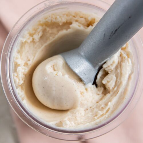A top view of an ice cream tub with Snickerdoodle Ice Cream being scooped out using a metal ice cream scoop, perfectly prepared by the Ninja Creami.