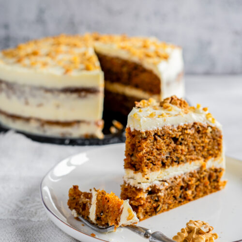 a slice of carrot cake on a plate with a fork.