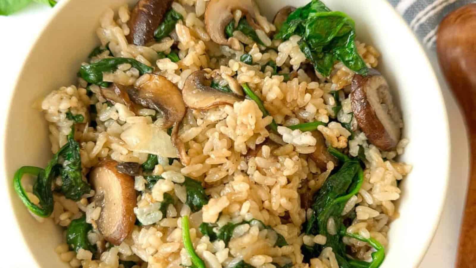 A bowl of rice mixed with mushrooms, spinach, and herbs.